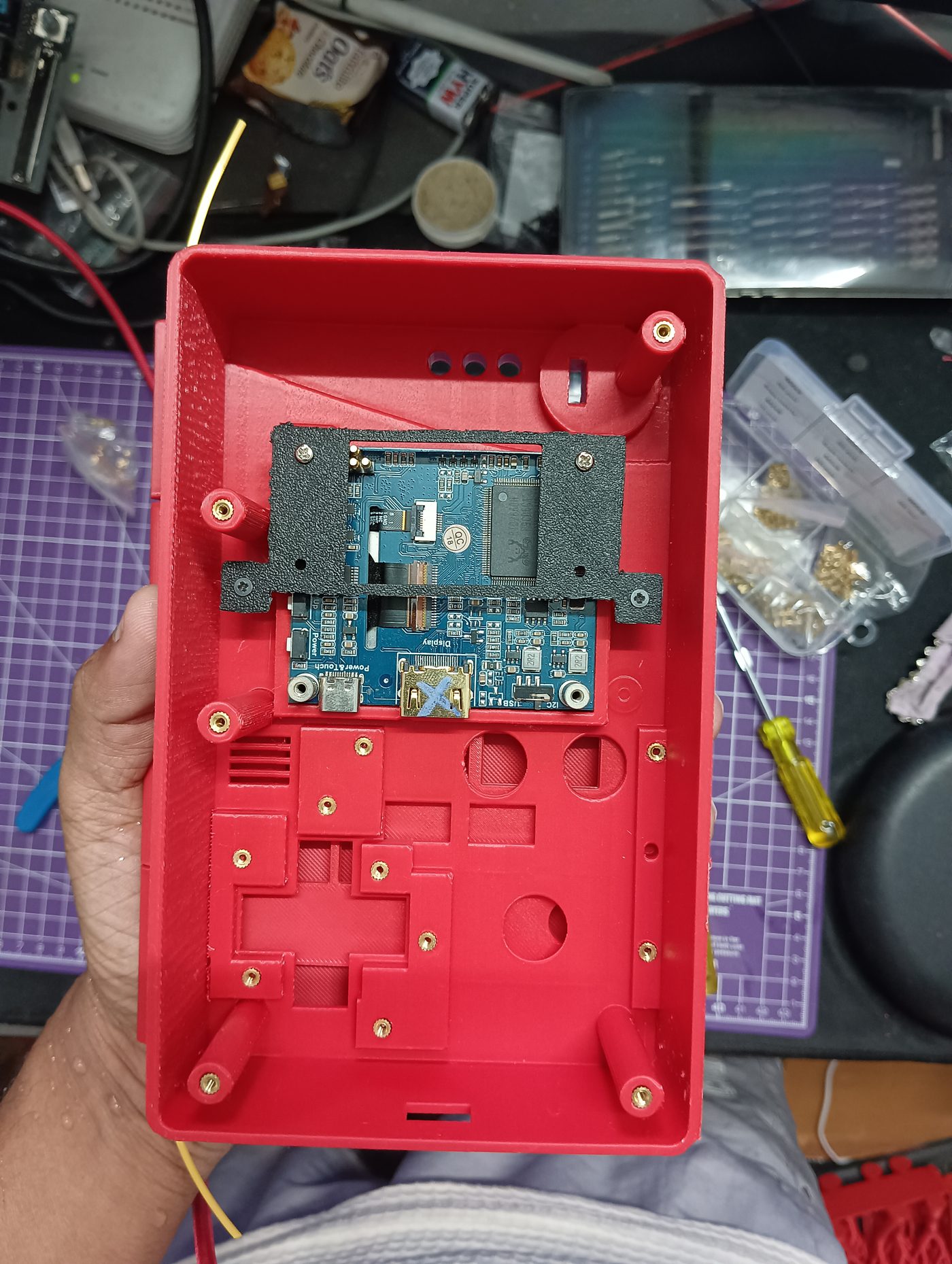 Back panel with the display fitted and brass heat-set inserts installed